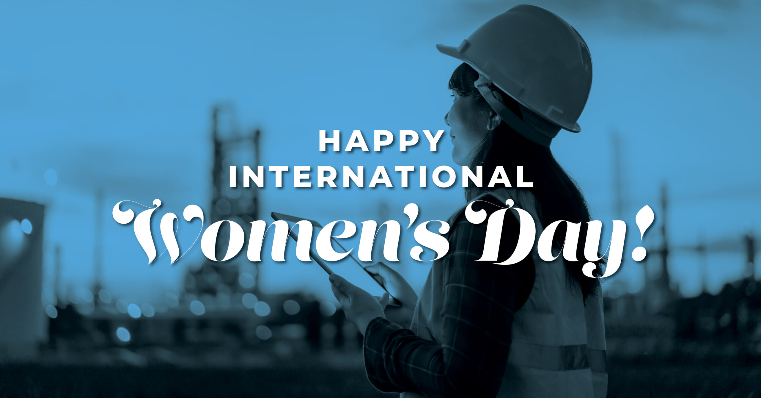 Women in hard hats and safety vests on a construction jobsite. Text reads Happy International Women's Day.